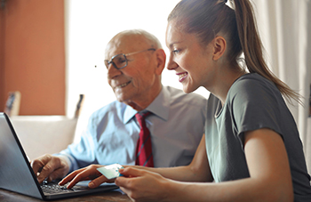 two people looking at a laptop smiling