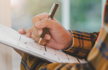 Person drawing on floor plan