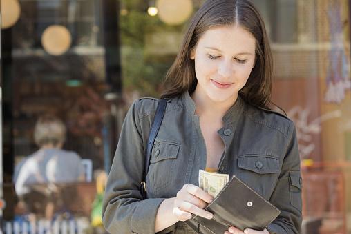 Woman taking cask out of wallet