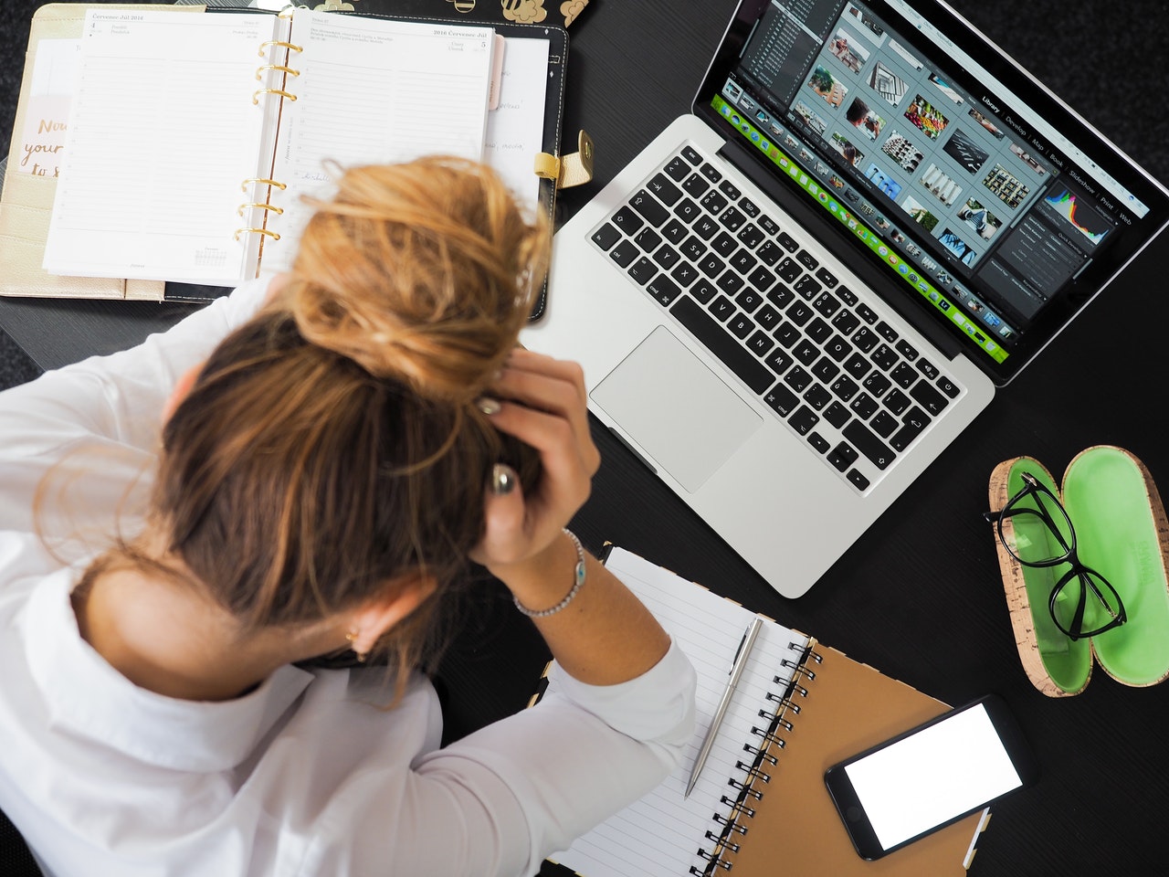 Woman with hand on head sitting at computer